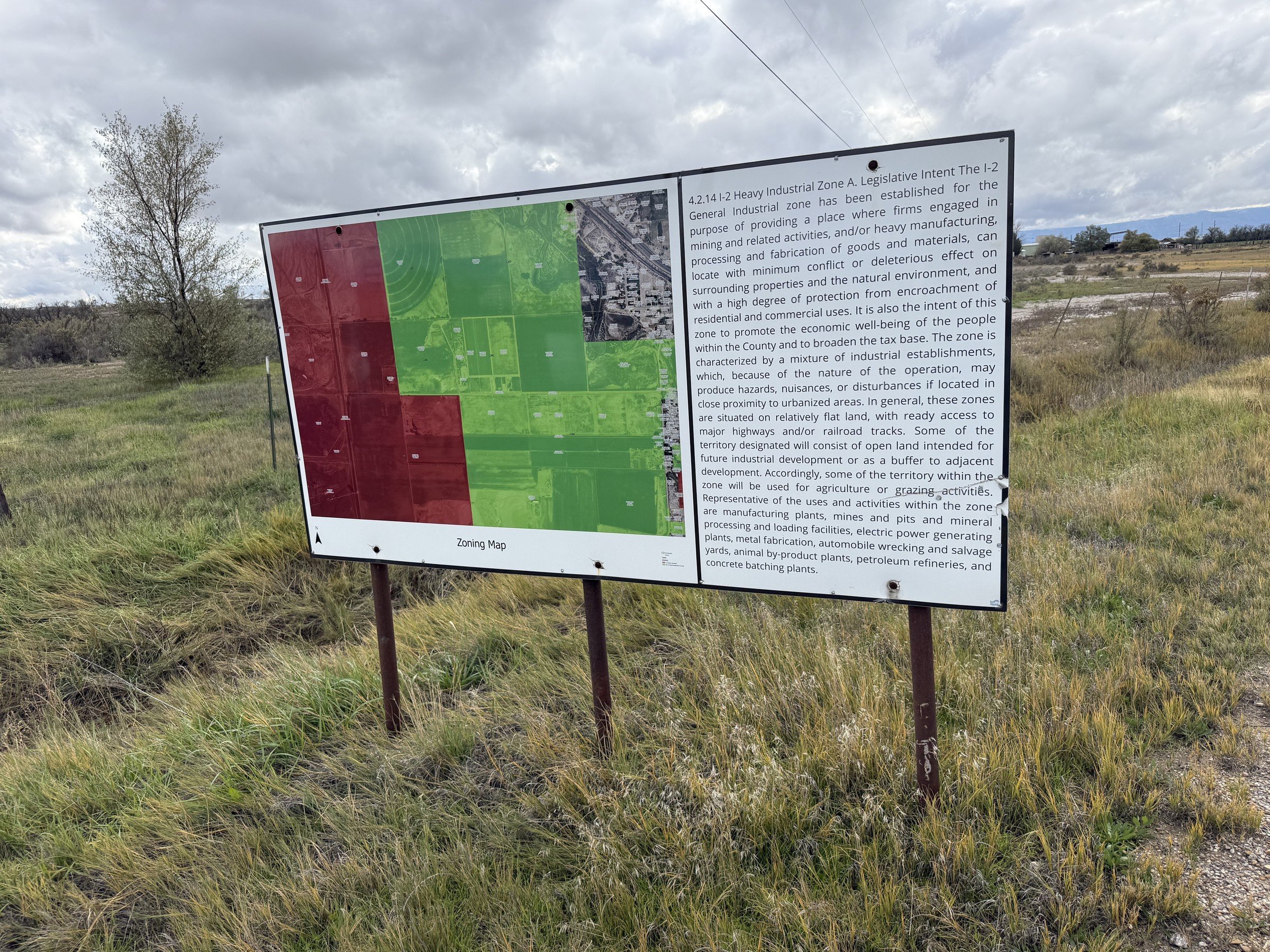 A sign beside the county’s Ridge Road park land carries the county development code’s description of the I-2 Heavy Industrial zone and a zoning map.